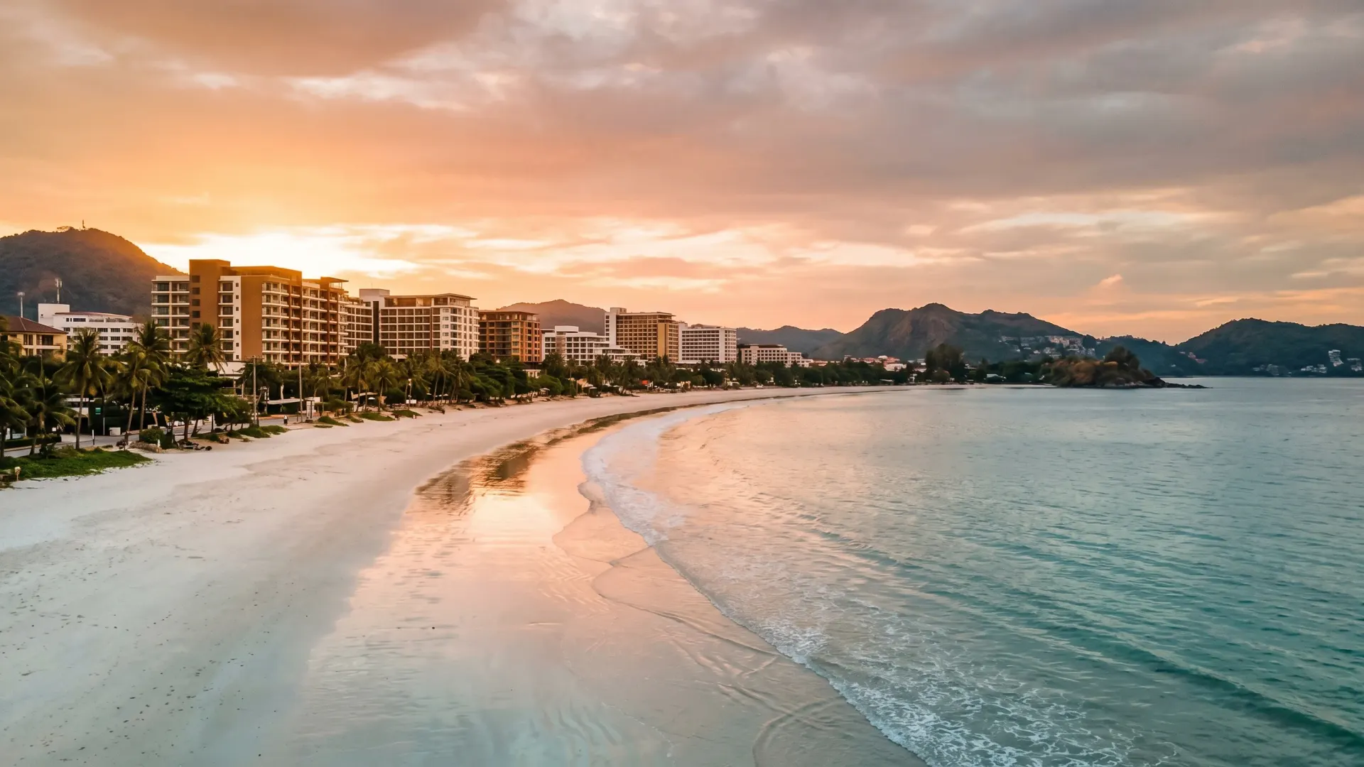 Patong Beach Phuket at sunset with high-rise condos and a restaurant-lined shore, illustrating the patong phuket villa market