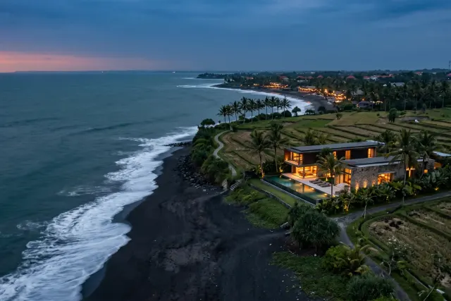 Berawa beach with morning surf breaking on dark volcanic sand